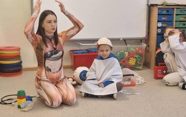 Prowadząca i dziecko prezentujący model m&oacute;zgu