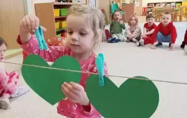 Makuch przypina klamerką serce do sznurka na pranie