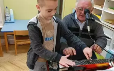 Chłopiec ćwiczy grę na instrumencie muzycznym