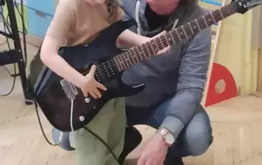 Chłopiec ćwiczy grę n a gitarze