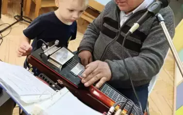 Chłopiec ćwiczy grę na instrumencie muzycznym