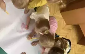 Dzieci rysujące na dużym arkuszu papieru.