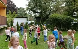 Zabawy w ogrodzie przedszkolnym z bańkami mydlanymi.