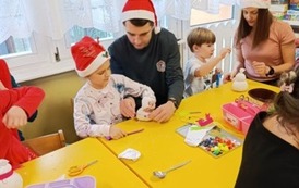 Dzieci i rodzice w czasie wykonywania ozdoby.