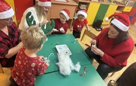 Rodzice i dzieci w czasie wykonywania ozd&oacute;b świtecznych.