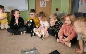 Chłopiec trzymający czarny balon wśr&oacute;d innych dzieci