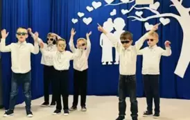 Chłopcy z grupy starszak&oacute;w z założonymi okularami przeciwsłonecznymi tańczą