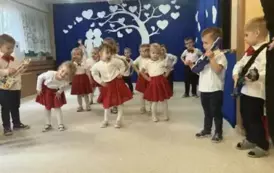 Dzieci z grupy 1 - chłopcy grają na gitarach, a dziewczynki tańczą