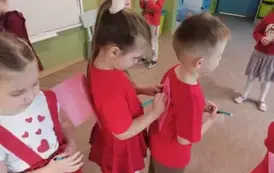 Średniaki ustawione w pociągu rysują obrazki na kartkach opartych o plecy kolegi