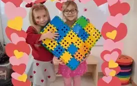 Dziewczynki pokazują serce zrobione z kolorowych klock&oacute;w