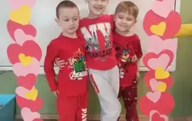 Tr&oacute;jka chłopc&oacute;w obejmuje się w walentynkowej fotoramce