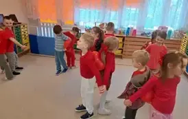 Dzieci tańczą w parach z balonem pomiędzy plecami
