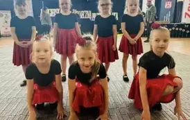 dziewczynki biorące udział w gali kucają na scenie